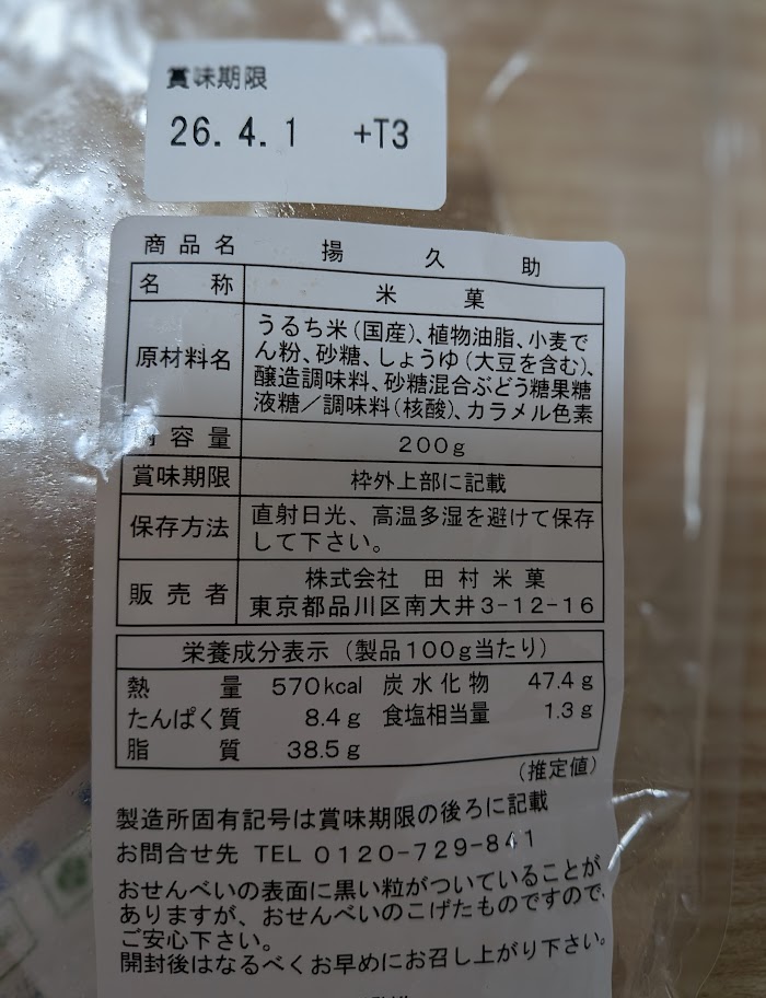 揚げせんべい「揚げ久助」のパッケージ裏面の栄養成分表示。100gあたり570kcalという驚異的なエネルギー量がはっきりと写っている。
